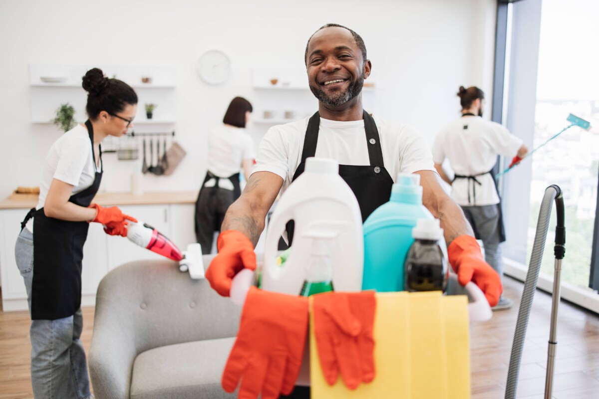 African man professional cleaning worker holding a bucket with detergents.